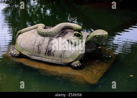 SINGAPORE: Turtle scultura con un serpente sulla sua schiena nella laguna è un simbolo di buona fortuna al giardino cinese * Foto Stock