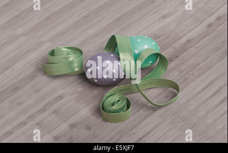 Le uova di pasqua decorare con la polka tinti uova e un nastro su sfondo di legno (offuscata colori) Foto Stock