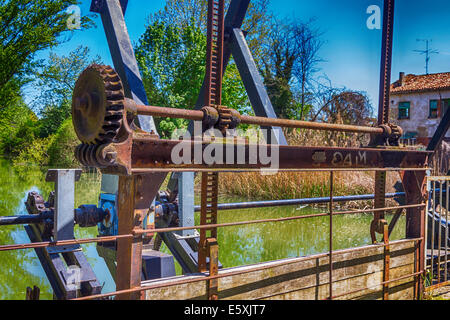 Vecchi ingranaggi arrugginiti di un gate di regolamentazione Foto Stock