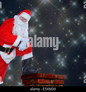 Babbo Natale in piedi su un tetto con un piede sul camino. I suoi bracci sono ripiegati e lui è appoggiata sul suo ginocchio contro un stellata Foto Stock