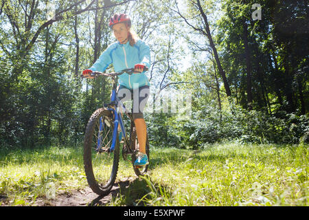 Giovane donna in mountain bike corsa veloce all'esterno. Foto Stock