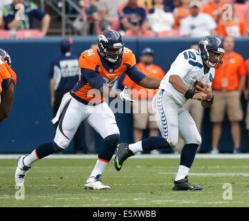 Denver, Colorado, Stati Uniti d'America. Il 7 agosto, 2014. Seattle QB RUSSELL WILSON corre da i Broncos difesa durante il gioco Pre-Season presso autorità sportive Field at Mile High giovedì sera. I Broncos battere il Seahawks 21-16. Credito: Hector Acevedo/ZUMA filo/Alamy Live News Foto Stock