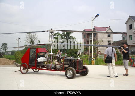 Dexing, Cina. Il 7 agosto, 2014. Agosto 07: Jiang Changgen si prepara per la prova di volo a Dajia village il 7 agosto 2014 in Dexing, Jiangxi provincia della Cina. Il 52-anno-vecchio Changgen Jiang ha trascorso due anni e 100.000 yuan (16,200 USD) rendendo il coassiale elicottero. L'elicottero è lunga 4 metri, 2,65 metri di altezza e pesa 900 kg. La sua lama del rotore è di 8 metri di lunghezza. Jiang ha cercato più di dieci minuti, ma non vi riuscì. Credito: SIPA Asia/ZUMA filo/Alamy Live News Foto Stock