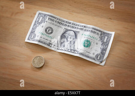 Un dollaro e una sterlina britannica moneta su un tavolo. Foto Stock
