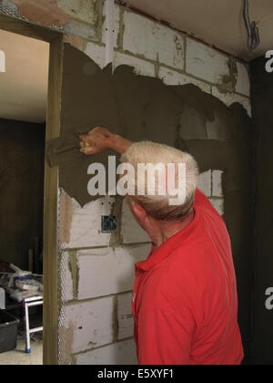 Stuccatore intonacatura di pareti interne di un albergo costruito di recente / estensione ad un home Foto Stock