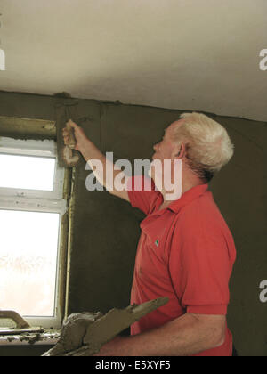 Stuccatore intonacatura di pareti interne di un albergo costruito di recente / estensione ad un home Foto Stock