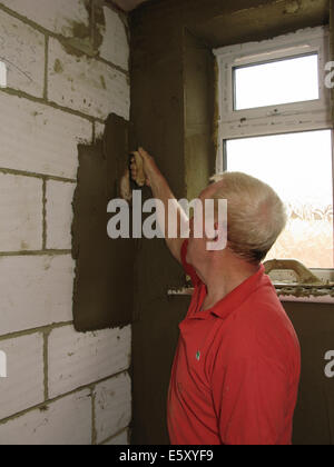 Stuccatore intonacatura di pareti interne di un albergo costruito di recente / estensione ad un home Foto Stock