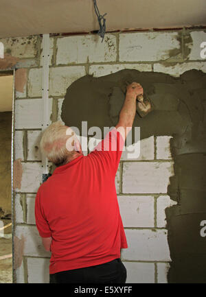 Stuccatore intonacatura di pareti interne di un albergo costruito di recente / estensione ad un home Foto Stock