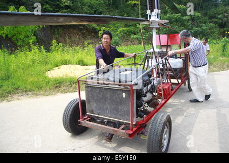 Dexing, Cina. Il 7 agosto, 2014. Agosto 07: Jiang Changgen si prepara per la prova di volo a Dajia village il 7 agosto 2014 in Dexing, Jiangxi provincia della Cina. Il 52-anno-vecchio Changgen Jiang ha trascorso due anni e 100.000 yuan (16,200 USD) rendendo il coassiale elicottero. L'elicottero è lunga 4 metri, 2,65 metri di altezza e pesa 900 kg. La sua lama del rotore è di 8 metri di lunghezza. Jiang ha cercato più di dieci minuti, ma non vi riuscì. Credito: SIPA Asia/ZUMA filo/Alamy Live News Foto Stock