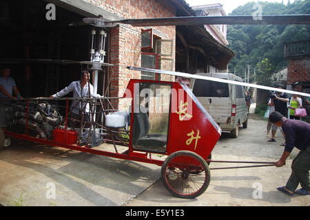 Dexing, Cina. Il 7 agosto, 2014. Agosto 07: Jiang Changgen si prepara per la prova di volo a Dajia village il 7 agosto 2014 in Dexing, Jiangxi provincia della Cina. Il 52-anno-vecchio Changgen Jiang ha trascorso due anni e 100.000 yuan (16,200 USD) rendendo il coassiale elicottero. L'elicottero è lunga 4 metri, 2,65 metri di altezza e pesa 900 kg. La sua lama del rotore è di 8 metri di lunghezza. Jiang ha cercato più di dieci minuti, ma non vi riuscì. Credito: SIPA Asia/ZUMA filo/Alamy Live News Foto Stock