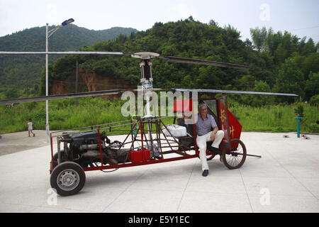 Dexing, Cina. Il 7 agosto, 2014. Agosto 07: Jiang Changgen si prepara per la prova di volo a Dajia village il 7 agosto 2014 in Dexing, Jiangxi provincia della Cina. Il 52-anno-vecchio Changgen Jiang ha trascorso due anni e 100.000 yuan (16,200 USD) rendendo il coassiale elicottero. L'elicottero è lunga 4 metri, 2,65 metri di altezza e pesa 900 kg. La sua lama del rotore è di 8 metri di lunghezza. Jiang ha cercato più di dieci minuti, ma non vi riuscì. Credito: SIPA Asia/ZUMA filo/Alamy Live News Foto Stock