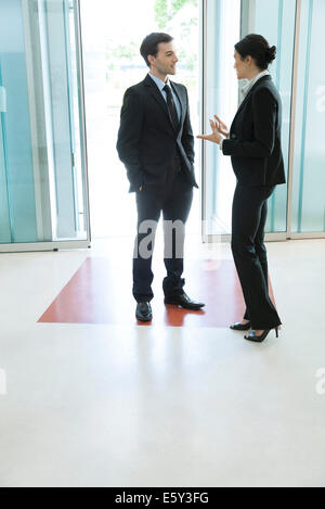 Business Associates parlando nella lobby Foto Stock