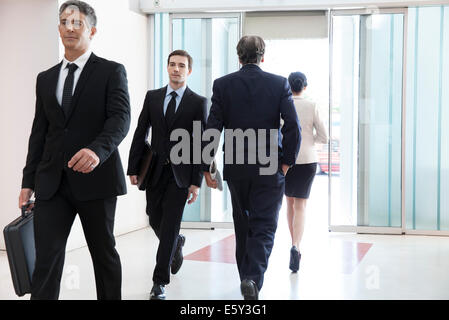 I professionisti aziendali passando attraverso office lobby Foto Stock