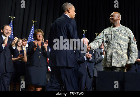 Il Presidente degli Stati Uniti Barack Obama (C) scuote le mani con US Army Sgt. Principali McGruder James, come Veterans Affairs Segretario Robert McDonald (L) applaude prima di Obama firma HR 3230, veterani' accesso alle cure attraverso la scelta, la responsabilità e la trasparenza atto di 2014, 7 agosto 2014, a Fort Belvoir, Virginia. Il disegno di legge mira a coadiuvare il veterano militare salute cura semplificando la va la burocrazia in aree quali gli appuntamenti e la formazione del personale e il personale medico va in strutture di assistenza. Credito: Mike Theiler / Pool via CNP - Nessun servizio di filo- Foto Stock