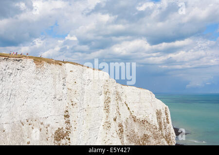 La gente camminare lungo le bianche scogliere di Dover Foto Stock