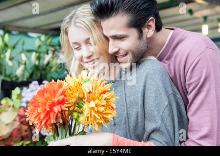 L uomo vuole girlfiend con regalo a sorpresa di fiori Foto Stock