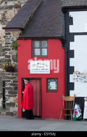 Signora in abito tradizionale al di fuori della più piccola casa in Galles, a Conwy in Galles del Nord. Foto Stock