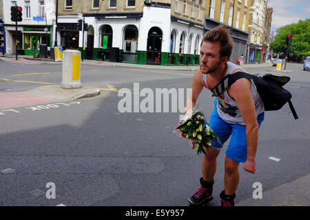 L'uomo sul rullo porta lame bouquet di fiori Foto Stock