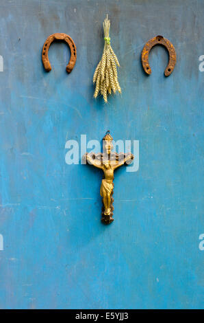 Concetto di sofferenza di Gesù Cristo, rusty Il ferro di cavallo e spighe di grano mazzetto sul blu parete in legno Foto Stock