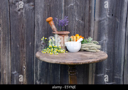 Antica di ferro arrugginito malta e varie erbe mediche sul vecchio tavolo in legno Foto Stock