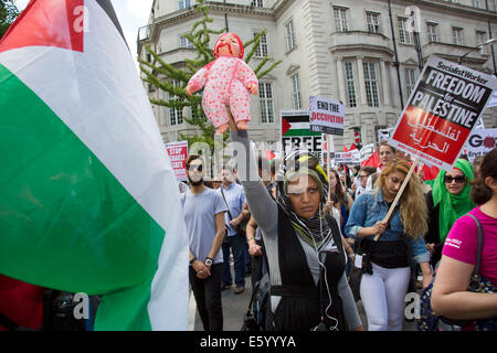 Londra, Regno Unito. Sabato 9 agosto 2014. Donna che mantiene una sanguinosa baby doll a significare l uccisione di bambini di Gaza. Pro-Palestinian manifestanti nella loro decine di migliaia di marzo attraverso il centro di Londra all'Ambasciata americana in segno di protesta contro l'offensiva militare a Gaza da parte di Israele. I cittadini britannici e British palestinesi raccolte in numero enorme portando cartelli e striscioni chiamando per 'Free Palestine' e di 'fine l assedio a Gaza". Credito: Michael Kemp/Alamy Live News Foto Stock