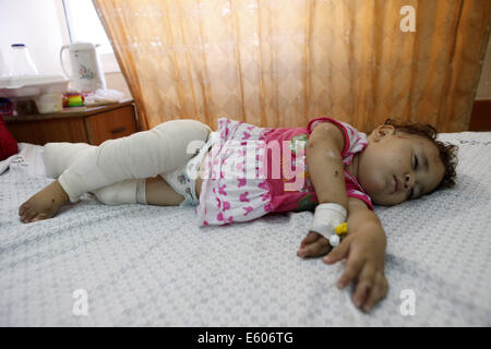 La striscia di Gaza City, nella Striscia di Gaza. 10 Ago, 2014. Mohammed Ali e Omar Wahdan della sorella, da Beit Hanoun nel nord della Striscia di Gaza, giace in un letto di al Shifa Hospital di Gaza City. Come il funzionamento Bordo di protezione è durato e amplificato e la sua famiglia hanno cercato rifugio in una scuola UNRWA; ma la scuola è stata bersaglio di incursioni aeree israeliane e la famiglia fuggita nuovamente al luogo più sicuro in una casa a Jabaliya Refugee Camp. Domenica 3 agosto, la casa è stata colpita da 3 missili israeliani che hanno ucciso e 4 feriti 11. Omar's madre venne ucciso suo padre è stata amputata, due dei suoi fratelli e a sua sorella erano ferire Foto Stock