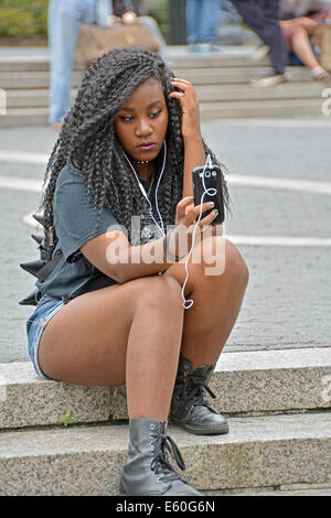 Una donna attraente in Union Square Park a New York City per scattare una foto di se stessa con un cellulare fotocamera. Foto Stock