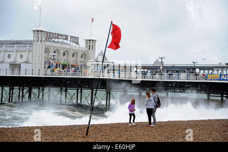 Brighton, East Sussex, Regno Unito. 10 Agosto, 2014. I visitatori a piedi sulla spiaggia di Brighton nel tempo burrascoso come ciò che si ritiene essere i resti dell uragano Bertha pastella Gran Bretagna oggi. Credito: Simon Dack/Alamy Live News Foto Stock