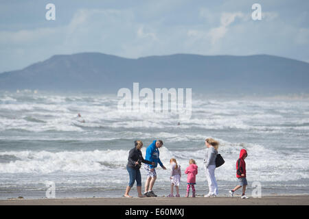 Borth, Ceredigion, Wales, Regno Unito. 10 Agosto, 2014.Alta venti sulla costa come la coda di uragano Bertha passa. In una pausa del tempo, una famiglia godere Godetevi una breve parentesi di sole sulla spiaggia di Borth, vicino a Aberystwyth Wales UK Credit: keith morris/Alamy Live News Foto Stock