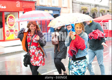 Brecon, Powys, Wales, Regno Unito. Il 10 agosto 2014. I frequentatori del festival non sono scoraggiati dalla pioggia che colpisce Brecon l'ultimo giorno del trentesimo Brecon Jazz Festival. Credito: Graham M. Lawrence/Alamy Live News. Foto Stock