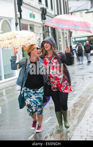 Brecon, Powys, Wales, Regno Unito. Il 10 agosto 2014. I frequentatori del festival non sono scoraggiati dalla pioggia che colpisce Brecon l'ultimo giorno del trentesimo Brecon Jazz Festival. Credito: Graham M. Lawrence/Alamy Live News. Foto Stock