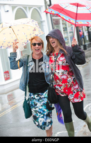 Brecon, Powys, Wales, Regno Unito. Il 10 agosto 2014. I frequentatori del festival non sono scoraggiati dalla pioggia che colpisce Brecon l'ultimo giorno del trentesimo Brecon Jazz Festival. Credito: Graham M. Lawrence/Alamy Live News. Foto Stock