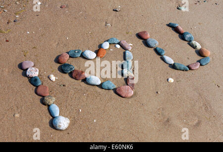 La frase "ti amo" fatta di pietre ghiaia sulla spiaggia sabbiosa Foto Stock