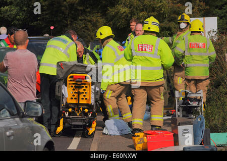 Bexhill, East Sussex, Regno Unito.10 agosto 2014. I servizi di emergenza in azione dopo un incidente stradale sulla A259 , Barnhorn Road, West di poco comune. Una signora è stata presa dalla scena di strada ambulanza polizia ha informato le ferite non erano gravi, evacuazione in elicottero non è stato richiesto da Kent orli che fu rapidamente sul sito. La gente del posto in corrispondenza della scena avvertire che questo è un normale incidente nero posto.. David Burr/Alamy Live News Foto Stock