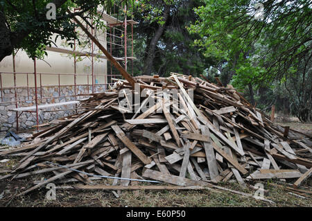 Grande pila di vecchie tavole di legno al sito in costruzione. Foto Stock