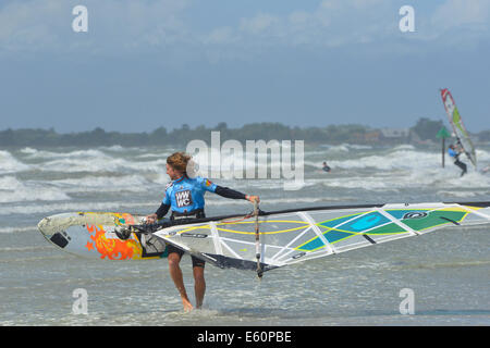 Windsurfers sulla West Wittering Beach dopo i resti di Bertha uragano che ha colpito la costa sud dell'Inghilterra. Foto Stock