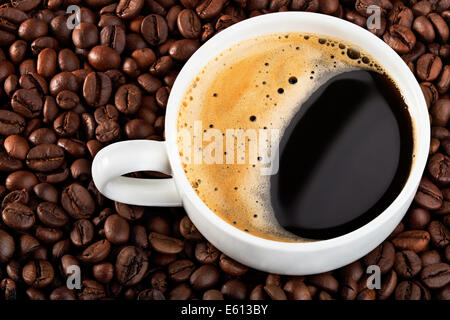 Sullo sfondo i chicchi di caffè con tazza bianca Foto Stock