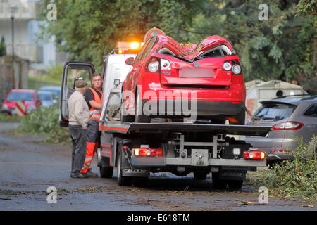 Bad Schwalbach, Germania. 11 Ago, 2014. Un golf car distrutta nella tempesta è trainato a Bad Schwalbach, Germania, 11 agosto 2014. Un forte tornado insieme con una tempesta di pioggia hanno provocato danni per milioni di persone. Numerose le vetture sono state danneggiate, tetti di case è venuto fuori e zone boschive distrutte. Foto: Fredrik von Erichsen/dpa/Alamy Live News Foto Stock