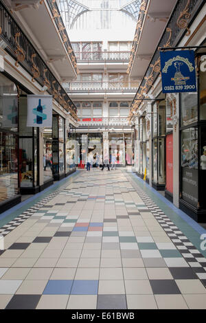 Scena di strada all'interno di Victorian shopping arcade coperto da un tetto di vetro. Barton Arcade, Deansgate, Manchester, Inghilterra, Regno Unito, Gran Bretagna Foto Stock