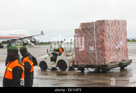 Conakry Guinea. 11 Ago, 2014. Il trasporto dei lavoratori il virus di Ebola di forniture di soccorso fornito dalla Cina all'aeroporto di Conakry, capitale della Guinea, 11 Agosto, 2014. Un Cinese piano di emergenza trasporto di rifornimenti umanitari in Guinea, Sierra Leone e Liberia sbarcati qui il lunedì per aiutare i tre paesi dell Africa occidentale lotta contro un focolaio di epidemia ebola. Le forniture del valore di 30 milioni di yuan (4,9 milioni di dollari) includono medical indumenti protettivi, disinfettanti, termo-rilevatori e farmaci. Credito: Youssouf Bah/Xinhua/Alamy Live News Foto Stock