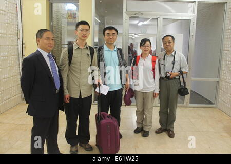 Conakry. 11 Ago, 2014. Tre cinese di controllo della malattia di esperti (da 2L a seconda R) arrivano all'aeroporto di Conakry, capitale della Guinea, 11 Agosto, 2014. Il Servizio Sanitario Nazionale e la pianificazione familiare Commissione (NHFPC) ha annunciato il Sabato che la Cina avrebbe inviato tre squadre di esperti e di forniture mediche per la Guinea, la Liberia e la Sierra Leone per aiutare la prevenzione e il controllo del virus Ebola. Credito: Xinhua/Alamy Live News Foto Stock