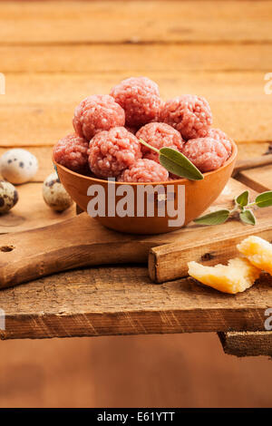 Materie le polpette di carne con la salvia su caldo sullo sfondo di legno Foto Stock