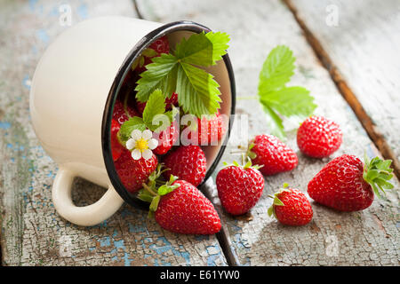 Le fragole in coppa su legno sfondo rustico Foto Stock