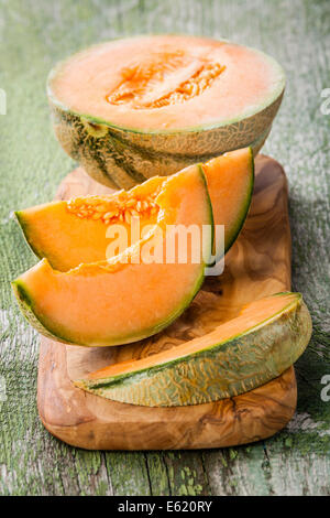 Melone fette di melone in legno di ulivo tagliere Foto Stock