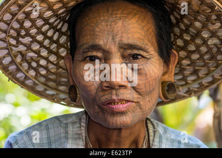 Una donna con il tradizionale tatuaggio del viso e orecchio gioielli, gruppo etnico del mento, appartenenti a una minoranza etnica, ritratto, Stato di Rakhine Foto Stock