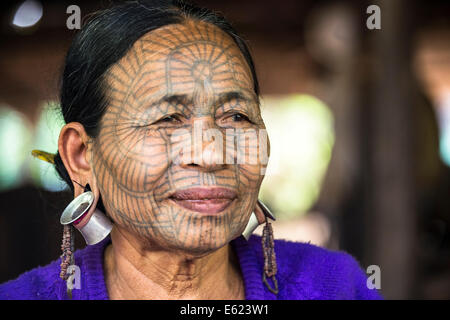 Una donna con il tradizionale tatuaggio del viso e orecchio gioielli, gruppo etnico del mento, appartenenti a una minoranza etnica, ritratto, Stato di Rakhine Foto Stock