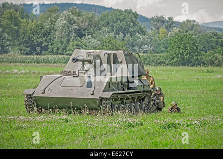 Soldati russi di nascondersi dietro un serbatoio mentre ci si avvicina a un campo di battaglia durante la rievocazione storica della II Guerra Mondiale combatte in Slovacchia Foto Stock