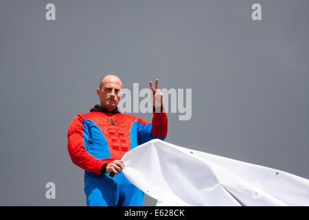 Londra, 12 agosto 2014. Un manifestante vestito come supereroe Spiderman dai Padri per la giustizia pende un banner dalla cima di Decimus Burton schermo ionica entrata a Hyde Park adiacente a Apsley House a Hyde Park Corner. Credito: Paolo Davey/Alamy Live News Foto Stock