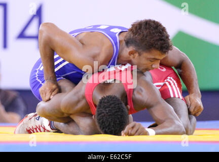 Abdulai Rogers di Sierra Leone (rosso) v Chamara Perera dello Sri Lanka (blu) nella mens Freestyle 65 kg wrestling Foto Stock