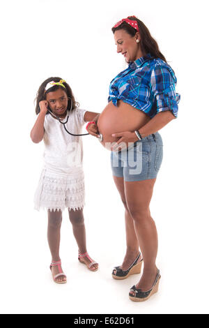 Ragazza giovane ascoltando la sua gravidanza madre ventre Foto Stock